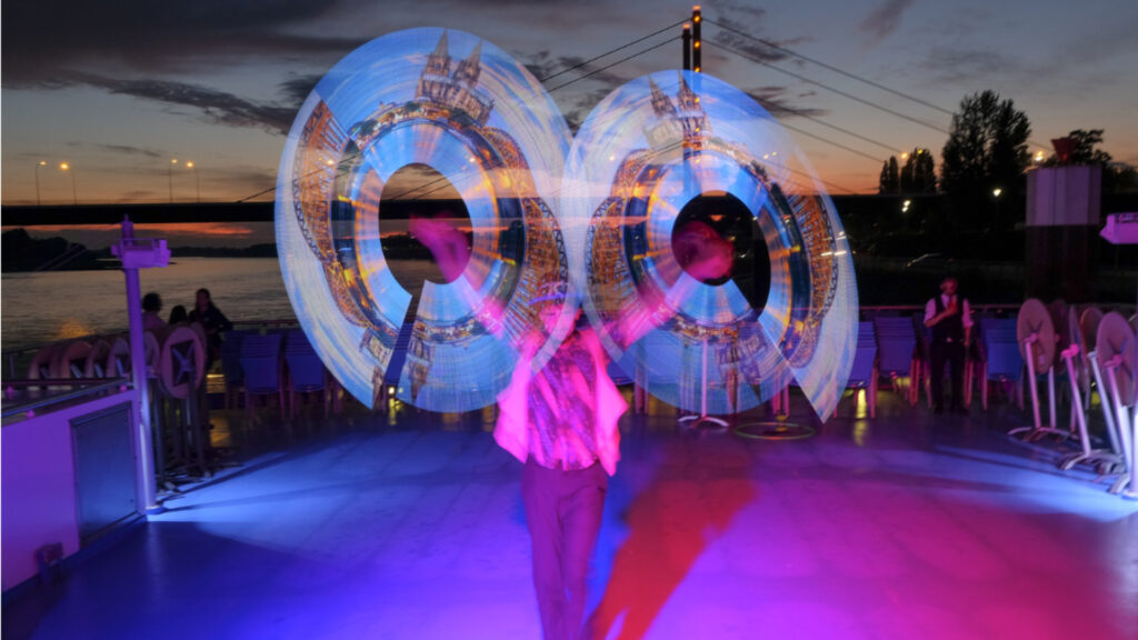 Spektakuläre LED-Lichtkunst bei einem Event auf dem Rhein, leuchtende Show bei Dämmerung.