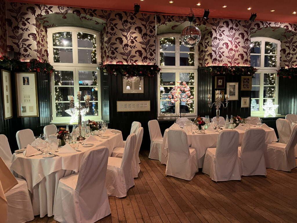 Exklusive Dinner-Location mit stilvoller Beleuchtung, festlichen Tischen und geschmackvollem Ambiente.