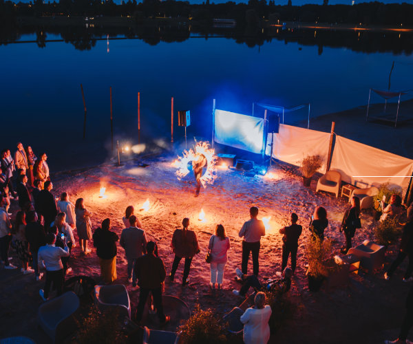 Firmensommerfest mit Feuershow am See in Köln bei Nacht. Gäste erleben ein emotionales Highlight bei einem professionell organisierten Outdoor Firmenevent