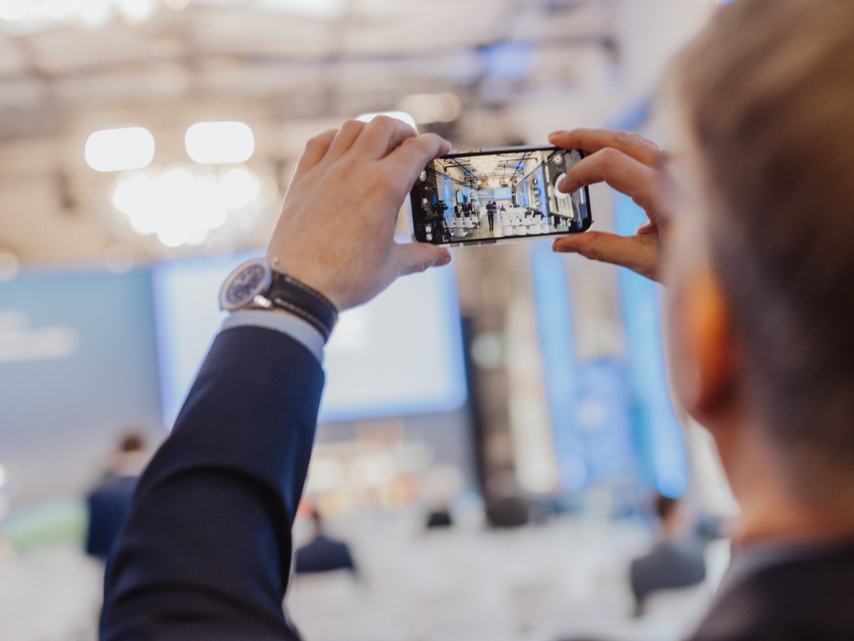 Teilnehmer fotografiert die Tagung in Köln mit dem Smartphone.