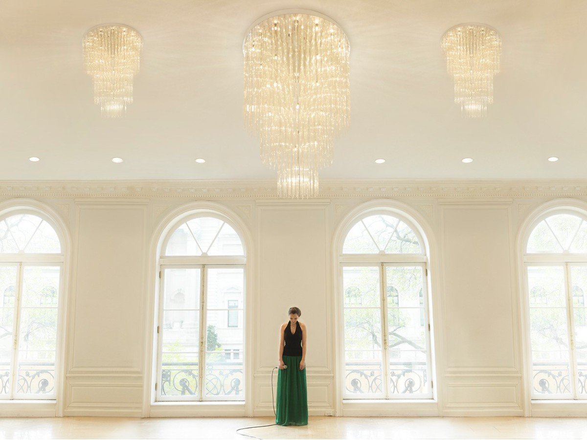 Künstlerportrait von Zuzanna Kies in einem stilvollen Raum mit hohen Fenstern und edlem Interieur.