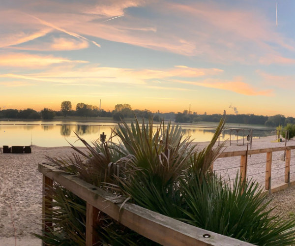 Eventlocation am See in Köln bei Sonnenuntergang. Die ruhige Atmosphäre zeigt eine ideale Location für ein exklusives Firmensommerfest im Freien