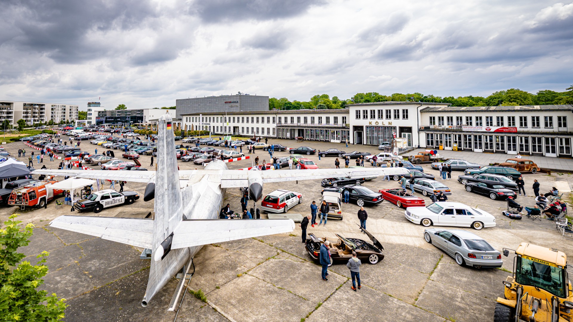 Eventlocation Köln Motorworld mit Oldtimern und Flugzeug. Großes Outdoor Event mit Besuchern.